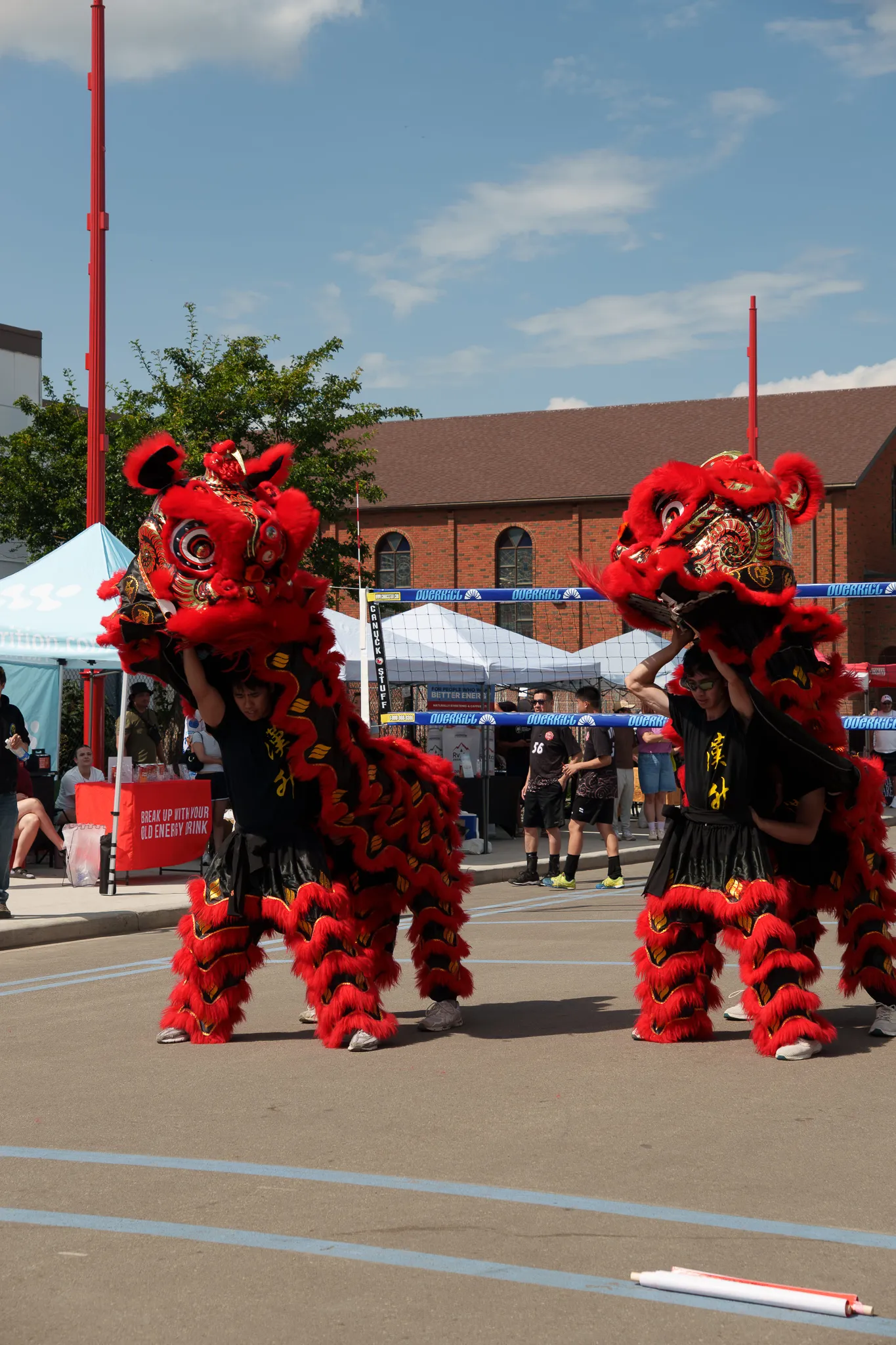 Two Hon Hsing lions performing at an outdoor community festival